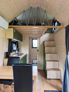 a tiny house with a dining table and a staircase at Accommodatie Spiegelwaal Nijmegen Lent in Nijmegen