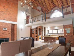a living room with a dining table and a kitchen at Sweet Zebula in Mabula