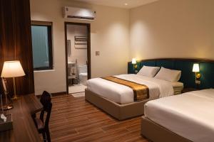 a hotel room with two beds and a desk at SOLANA VILLA Cửa Lò - Biệt thự nghỉ dưỡng cao cấp tiêu chuẩn 5 sao in Cửa Lô