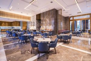 a restaurant with tables and chairs in a lobby at Mercure Xi'an Qujiang in Xi'an