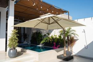 a tan umbrella sitting next to a swimming pool at SOLANA VILLA Cửa Lò - Biệt thự nghỉ dưỡng cao cấp tiêu chuẩn 5 sao in Cửa Lô