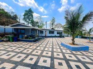 a house with a palm tree in front of it at Appa Hillside Nature Resort in Karjat