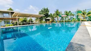 a large blue swimming pool in front of a building at Appa Hillside Nature Resort in Karjat
