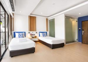 two beds in a room with blue and white at Citin Armoni Patong Hotel by Compass Hospitality - Newly Renovated in Patong Beach