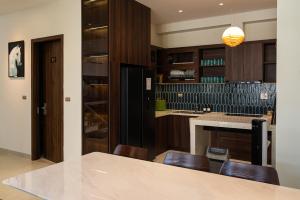 a kitchen with wooden cabinets and a table and chairs at SOLANA VILLA Cửa Lò - Biệt thự nghỉ dưỡng cao cấp tiêu chuẩn 5 sao in Cửa Lô