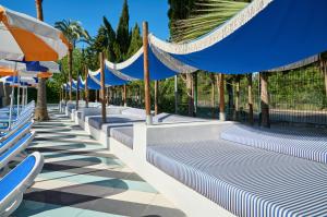 a row of beach chairs with umbrellas at tent Mojito Suites in Magaluf