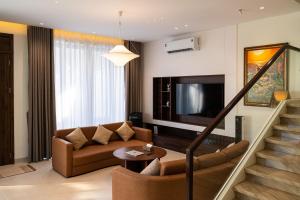 a living room with a couch and a television at SOLANA VILLA Cửa Lò - Biệt thự nghỉ dưỡng cao cấp tiêu chuẩn 5 sao in Cửa Lô