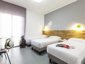 a room with four beds in a room with at Ibis Styles Brindisi in Brindisi