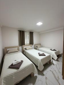 a room with three beds with towels on them at Apartmani Kastratovic in Golubovci