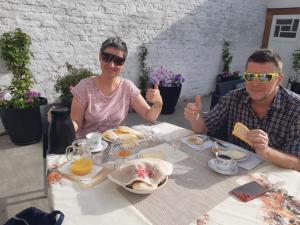 a man and woman sitting at a table eating food at B&B Casa Mama in Brugge in Bruges