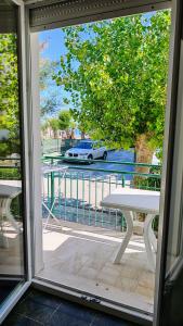 a sliding glass door with a table and a car on a street at vacanza in appartamento sul mare in Fano