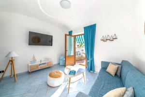 ein Wohnzimmer mit einem blauen Sofa und einem Tisch in der Unterkunft Hotel Punta Imperatore in Forio d'Ischia
