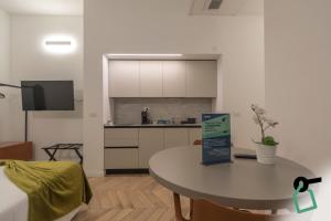 a kitchen and a table with a sign in a room at Hotiday Trieste Teatro in Trieste