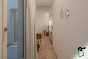 a hallway with a door open to a room with a table at Hotiday Trieste Teatro in Trieste