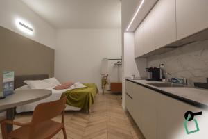 a room with a bed and a table and a sink at Hotiday Trieste Teatro in Trieste