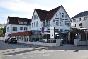 ein großes weißes Gebäude an der Ecke einer Straße in der Unterkunft Hotel Gorch Fock in Timmendorfer Strand