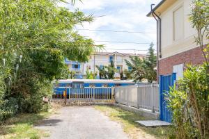 a blue fence in front of a house with a train at Italian Experience-Casale Oleandro Marino in Porto Recanati