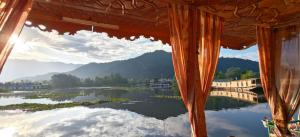 a view from a window of a river with mountains at Raja's Palace Houseboat - Lake View in Srinagar