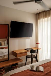 a bedroom with a desk and a tv on the wall at Deos- Luxury Apartment in Agrinio in Agrinio