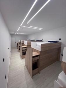 a large room with a row of tables and benches at Ferra Hostel in Durrës