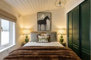 a bedroom with a bed with a horse picture on the wall at The Paddock Lodge in Withcote