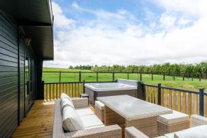 a deck with a hot tub and a table and chairs at The Paddock Lodge in Withcote