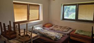 a room with two beds and a couch and windows at Nová Paka 1402 in Nová Paka