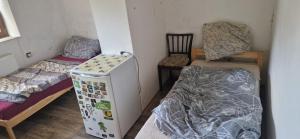 a room with a refrigerator and a bed and a chair at Nová Paka 1402 in Nová Paka