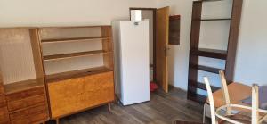 a room with a white refrigerator and a table and chairs at Nová Paka 1402 in Nová Paka