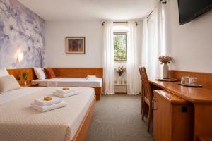 a hotel room with two beds and a desk at Hotel Kastil in Bol +27 photos