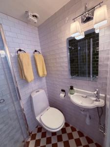 a bathroom with a white toilet and a sink at Hem till Bengt in Kungshamn