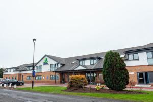 a building with a tree in front of it at Holiday Inn Express Edinburgh Airport by IHG in Ingliston