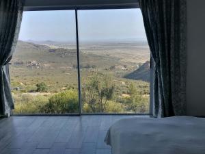 a bedroom with a large window with a view at Katkop Resort in Graafwater +9 photos