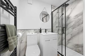 a white bathroom with a toilet and a shower at Umry-Calm Farm Stays in Feeny +43 photos