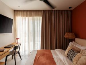 a hotel room with a bed and a desk and a window at Deos- Luxury Apartment in Agrinio in Agrinio