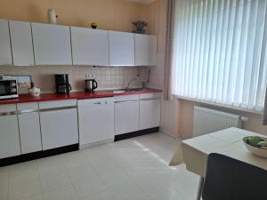 a small kitchen with white cabinets and a table at Ferienwohnung Waltraud in Brilon