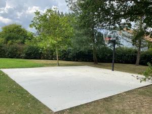 a basketball court with a hoop in a park at La Corti in Tillières-sur-Avre