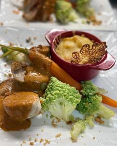 a plate of food with broccoli and other vegetables at Logis hôtel restaurant Auberge de la Cloche in Le Theil-sur-Huisne