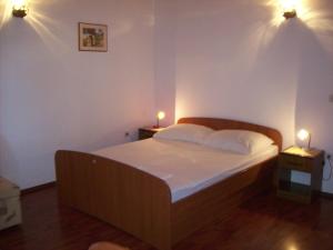 a bedroom with a bed with two lights on the wall at Captain's villa in Molunat