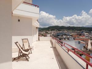 a balcony with two chairs and a view of a city at Deos- Luxury Apartment in Agrinio in Agrinio