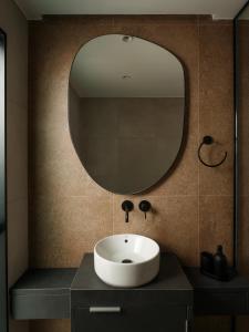 a bathroom with a sink and a mirror at Deos- Luxury Apartment in Agrinio in Agrinio +17 photos