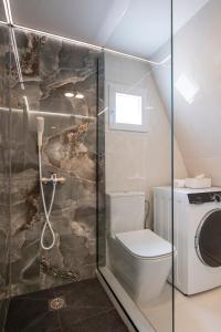 a bathroom with a toilet and a washing machine at Danae's A-Frame Nest in Daratso