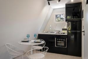 a kitchen with a black refrigerator and a table at Danae's A-Frame Nest in Daratso +23 photos