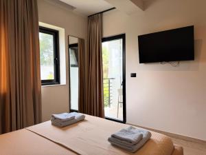 a bedroom with a bed with two towels on it at Ritson Hotel in Vlorë