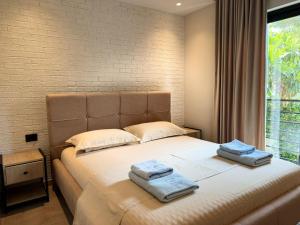 a bedroom with a large bed with towels on it at Ritson Hotel in Vlorë
