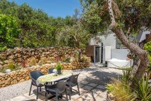 a patio with a table and chairs and a stone wall at Danae's A-Frame Nest in Daratso