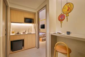 a small kitchen with a sink and a chair in a room at lyf Chinatown Singapore in Singapore