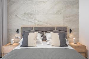 a bedroom with a bed with gray and white pillows at West Athens Luxurius Apartment in Athens