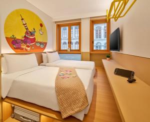 a bedroom with a large white bed and a tv at lyf Chinatown Singapore in Singapore