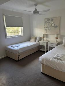 a bedroom with two beds and a window at Bella Vita Beach House in Robe